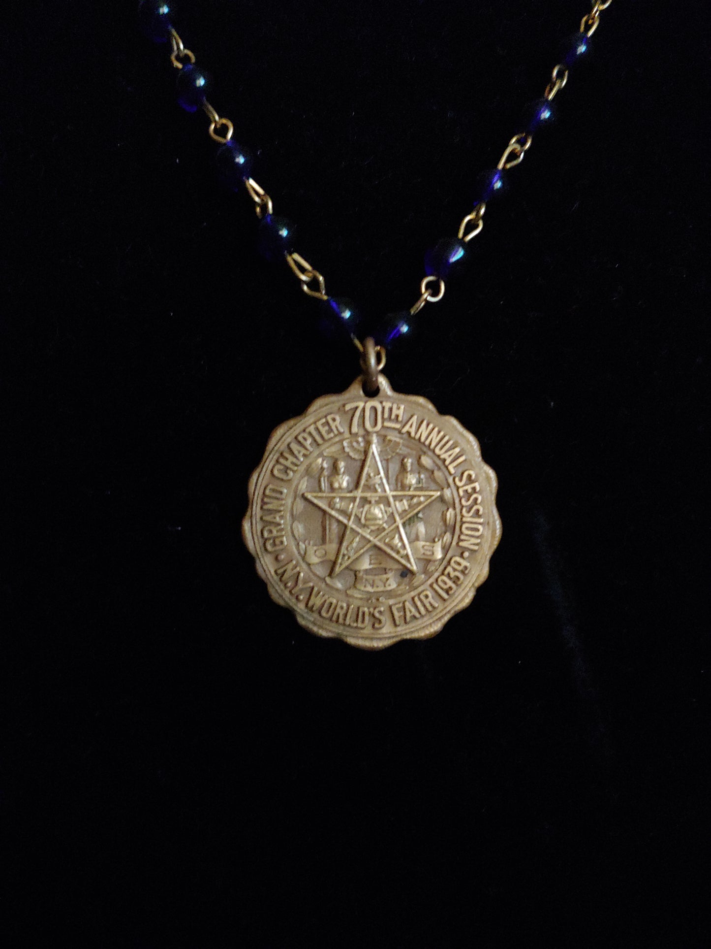 Brass charm on blue necklace