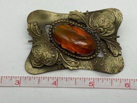 Brass and Amber brooch next to ruler