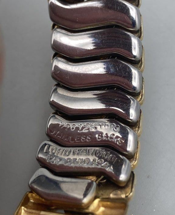 Close-up of a bracelet with engraved text on a gray background