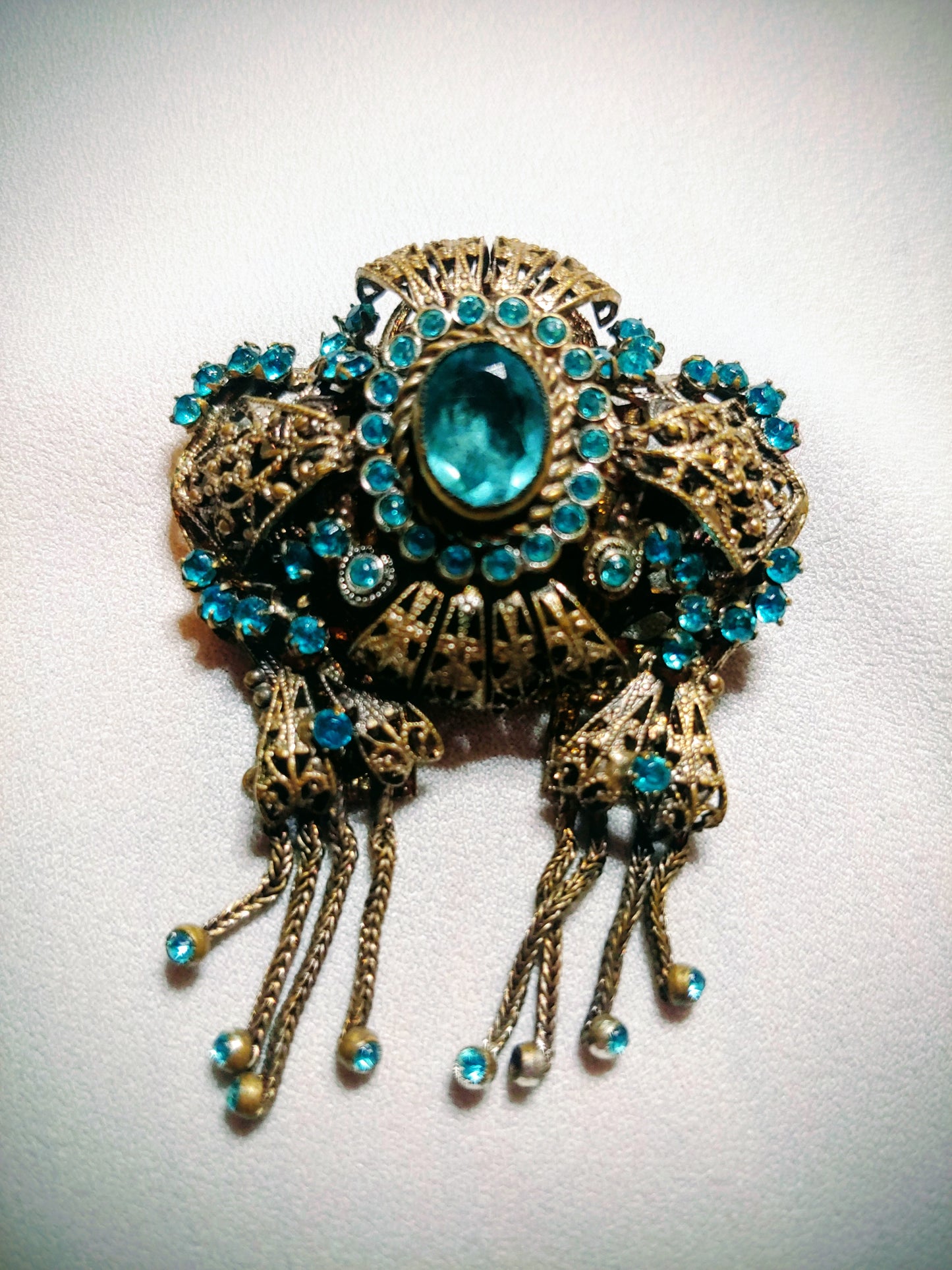 Decorative brooch with turquoise stones on a white background