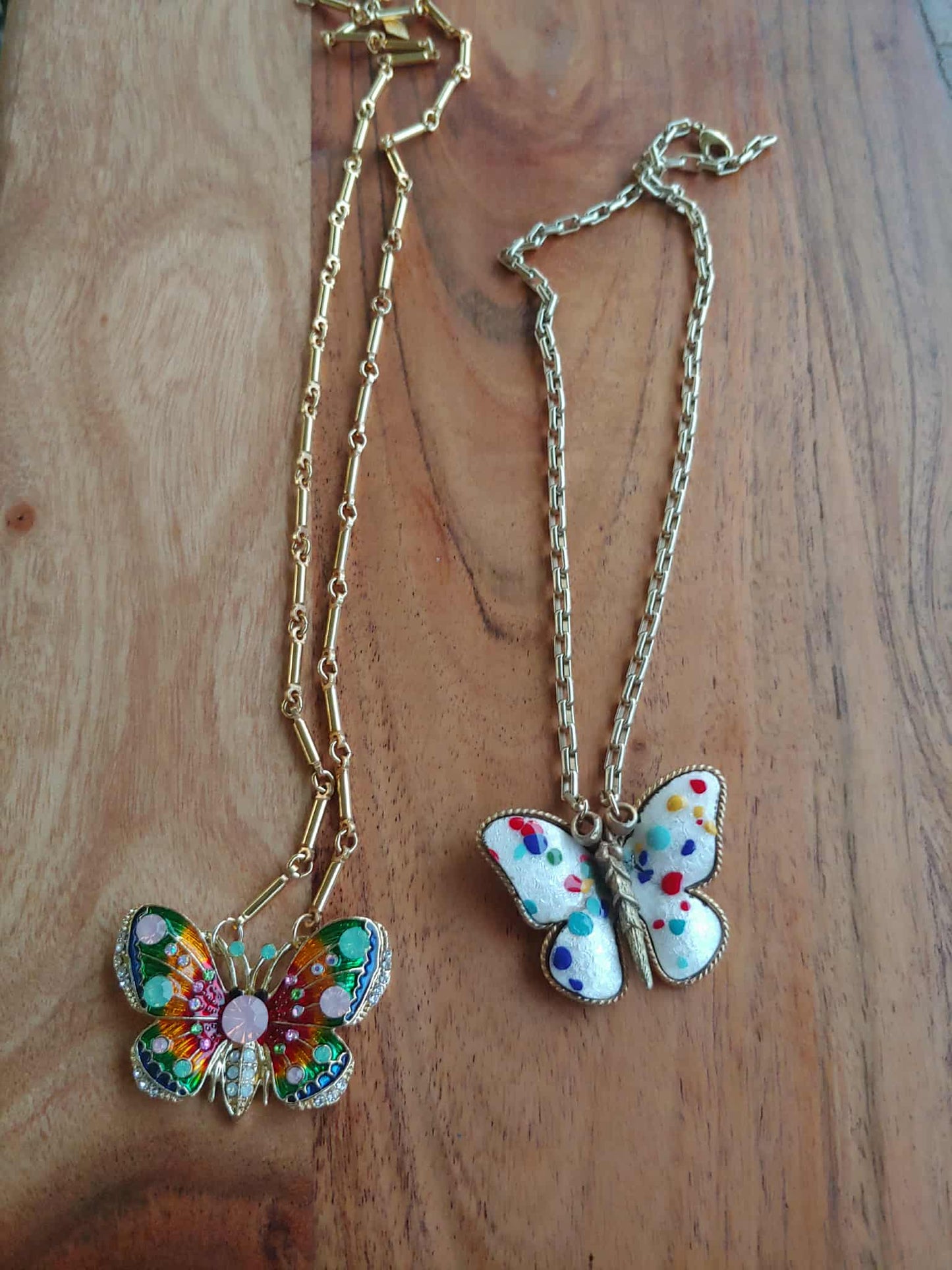 Butterfly-shaped necklaces on a wooden surface