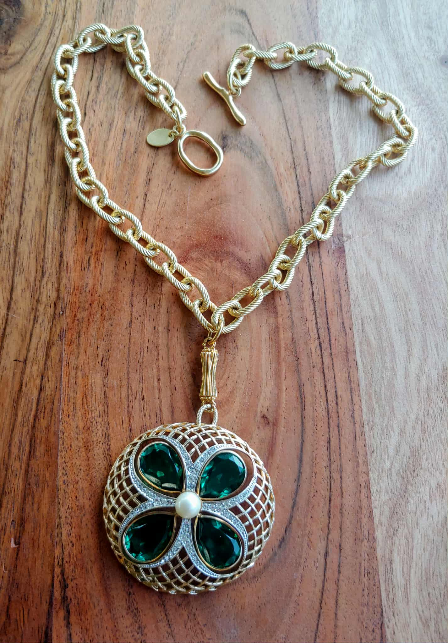 Necklace with a clover-shaped pendant on a wooden surface