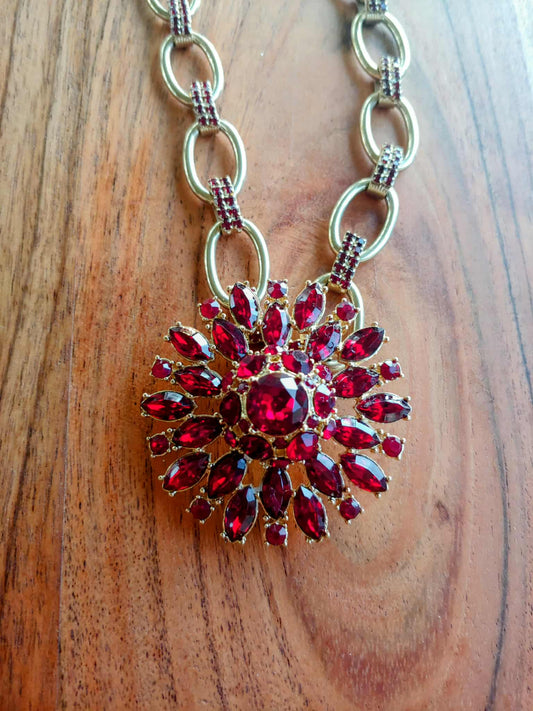 Necklace with a red pendant on a wooden surface