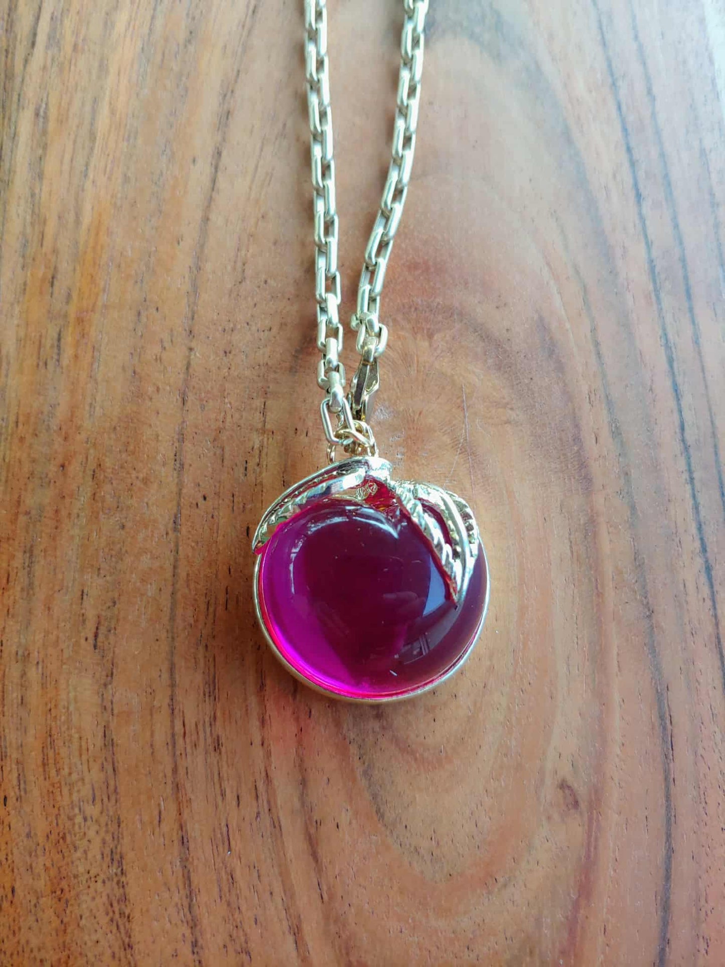 Necklace with a pink heart-shaped pendant on a wooden surface