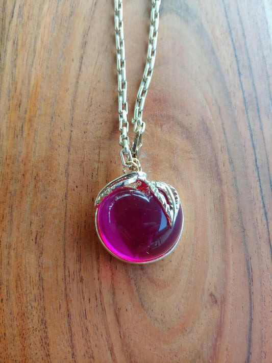 Necklace with a pink heart-shaped pendant on a wooden surface