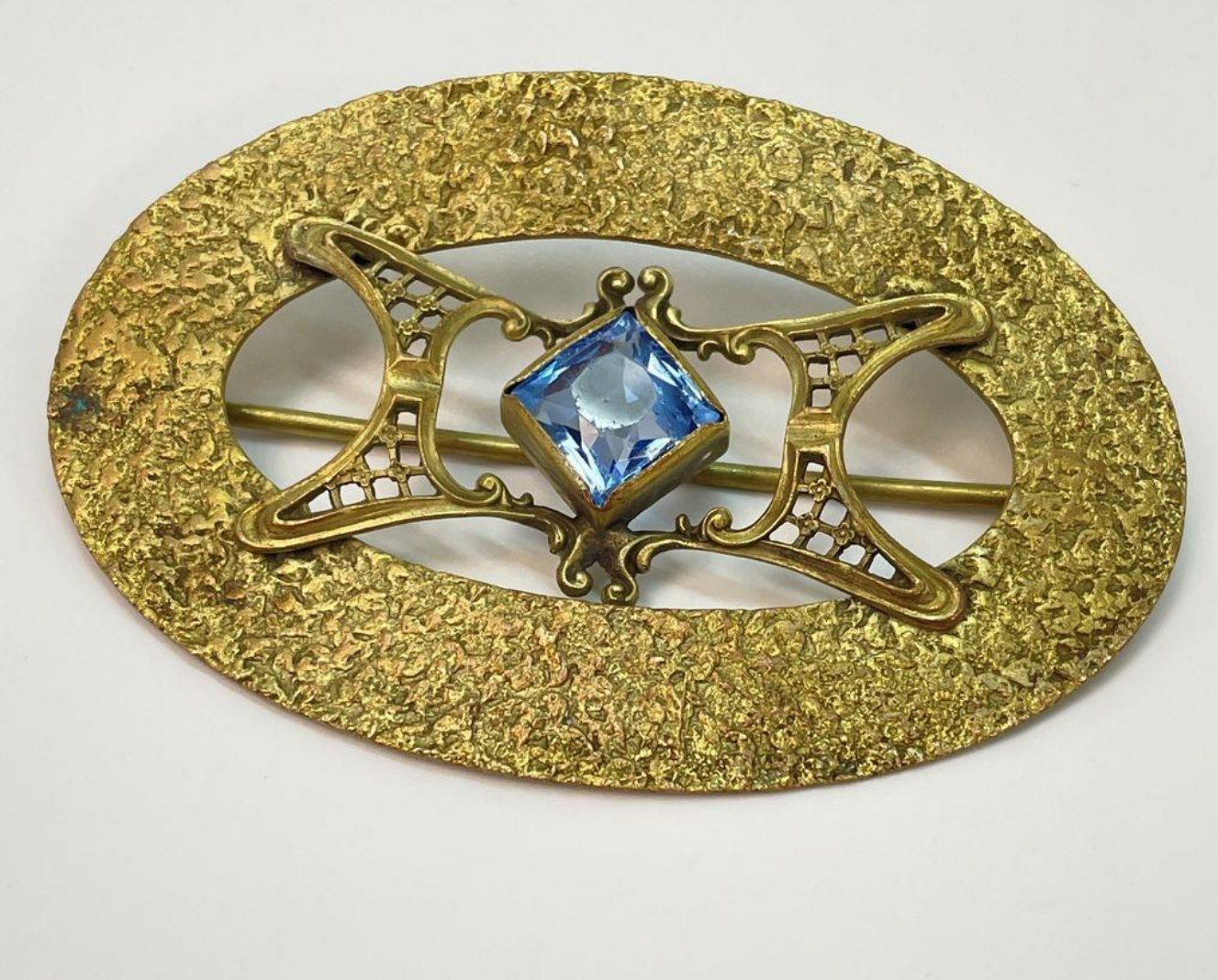 Brass brooch with blue glass