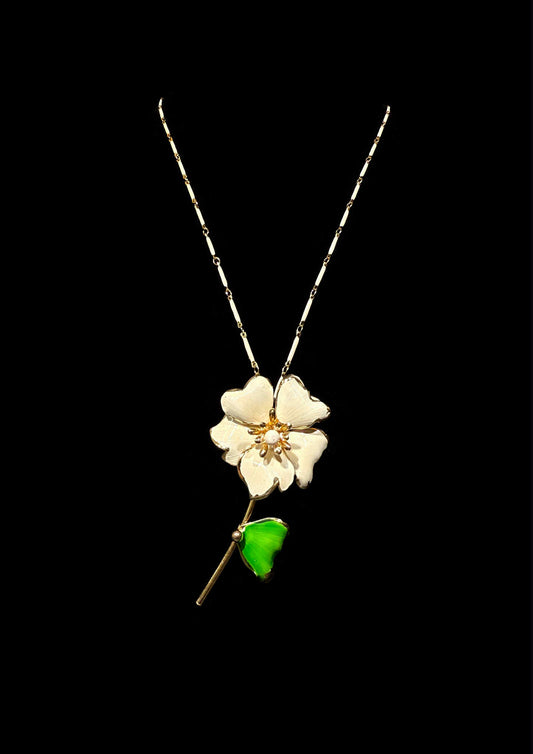 Floral pendant necklace with a green leaf on a black background