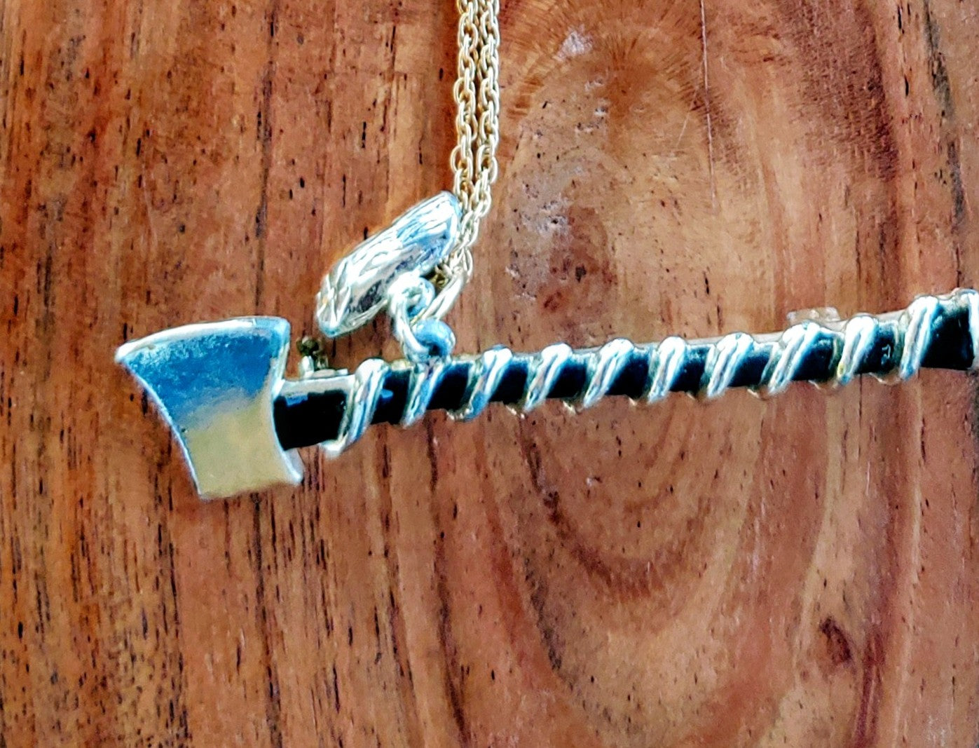 Necklace with a pendant shaped like a shark fin on a wooden background