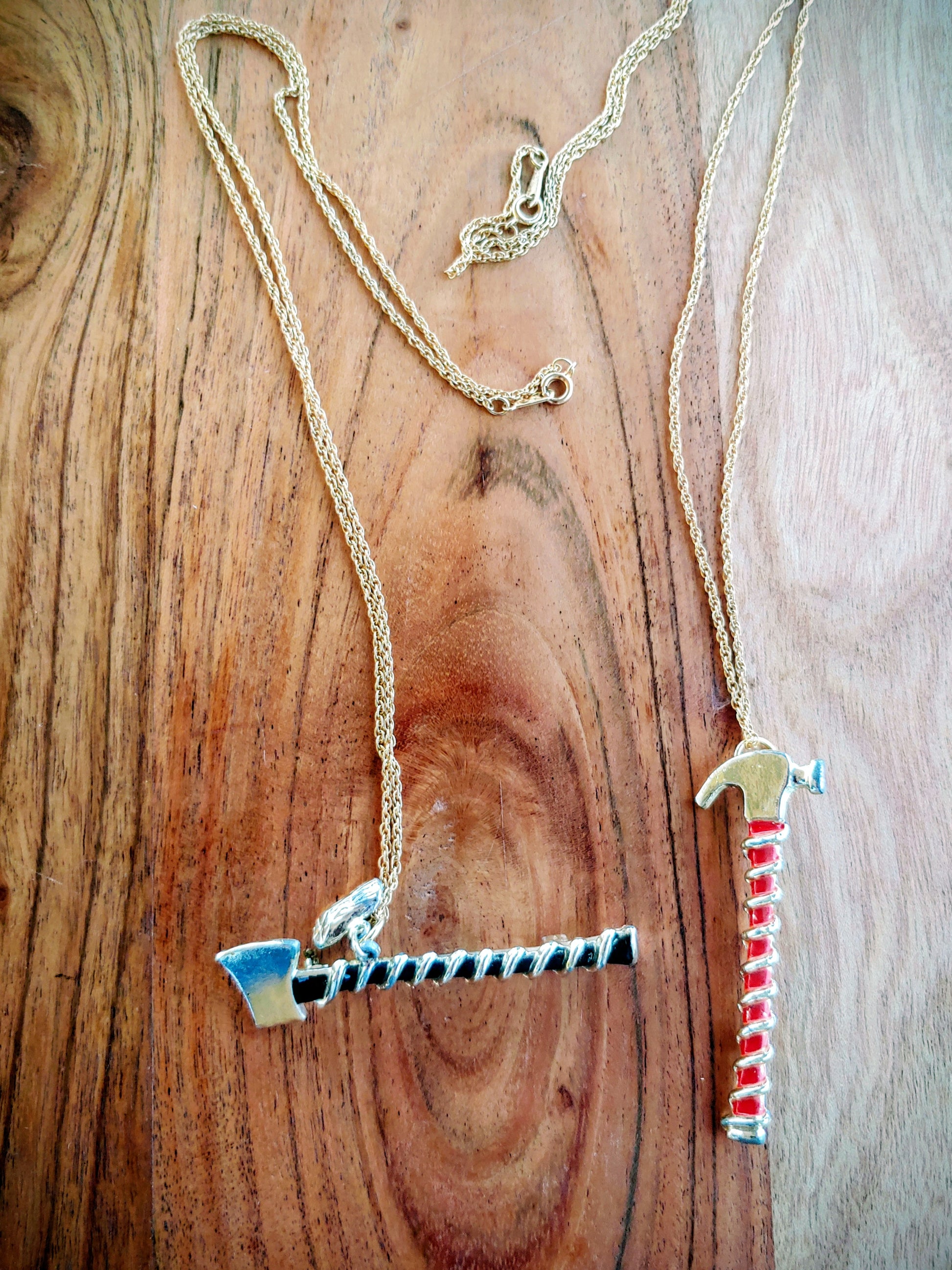 Two necklaces with unique pendants on a wooden surface
