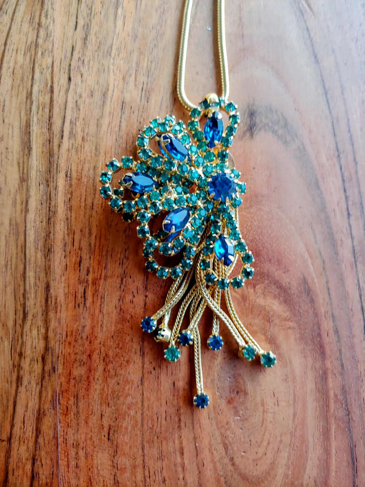 Decorative brooch with blue gemstones on a wooden surface