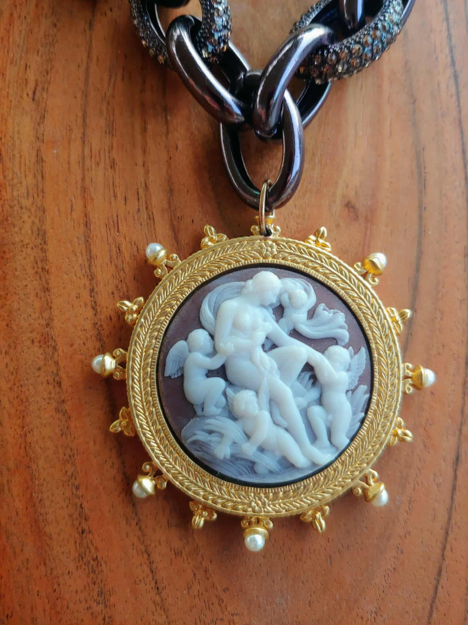 Gold-framed pendant with intricate design on a wooden surface