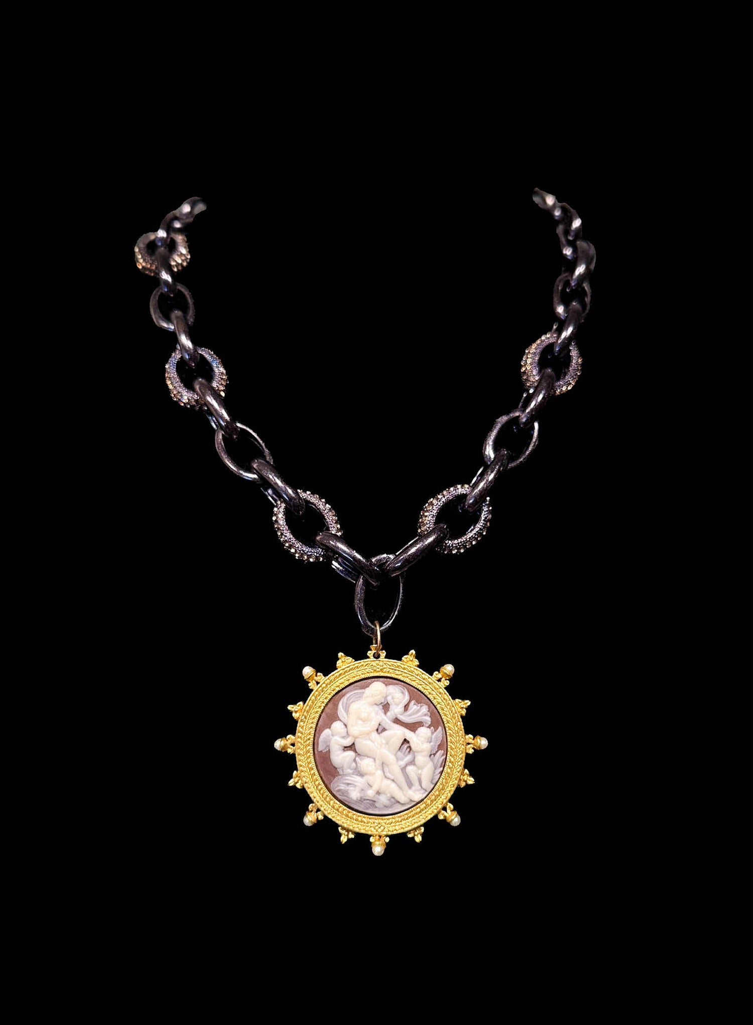 Necklace with a gold pendant featuring a cameo on a black background