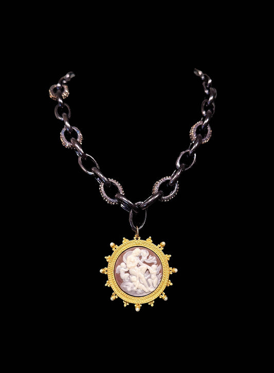 Necklace with a gold pendant featuring a cameo on a black background