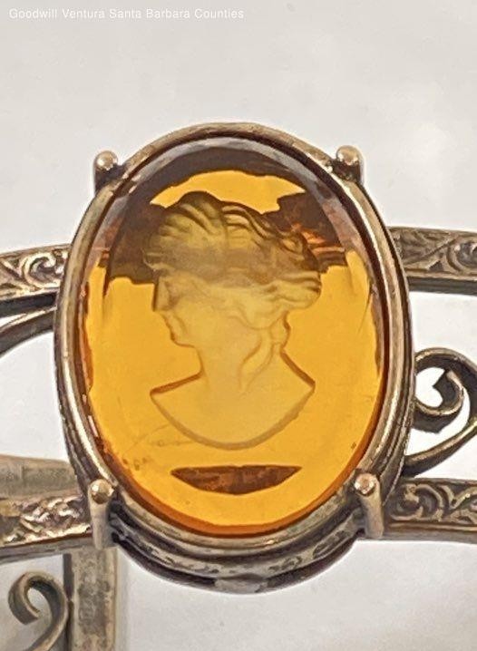 Bronze cuff bracelet with Abackgroundmber glass carving on white 