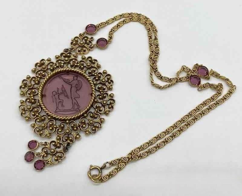 Purple glass pendant in gold necklace