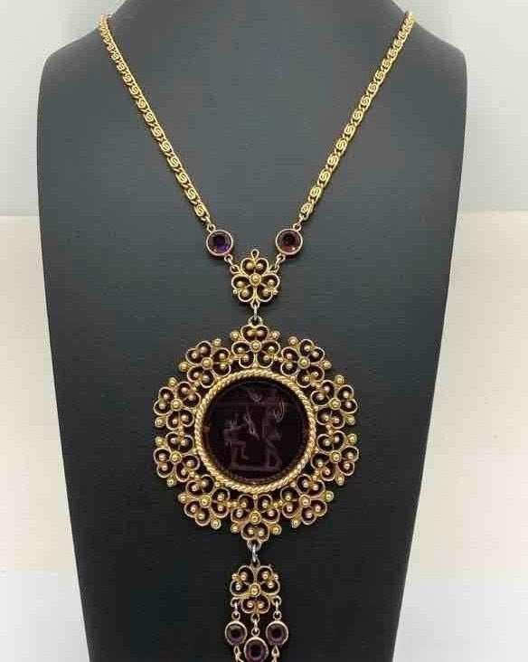 Purple glass pendant in gold necklace