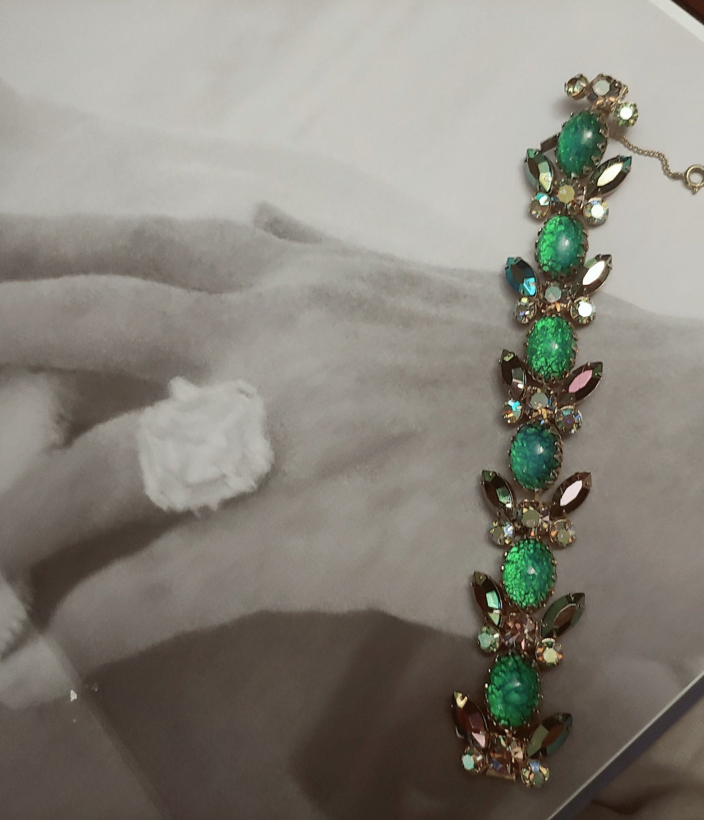 Green and blue bracelet on top of book with photo of hand