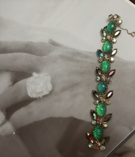 Green and blue bracelet on top of book with photo of hand