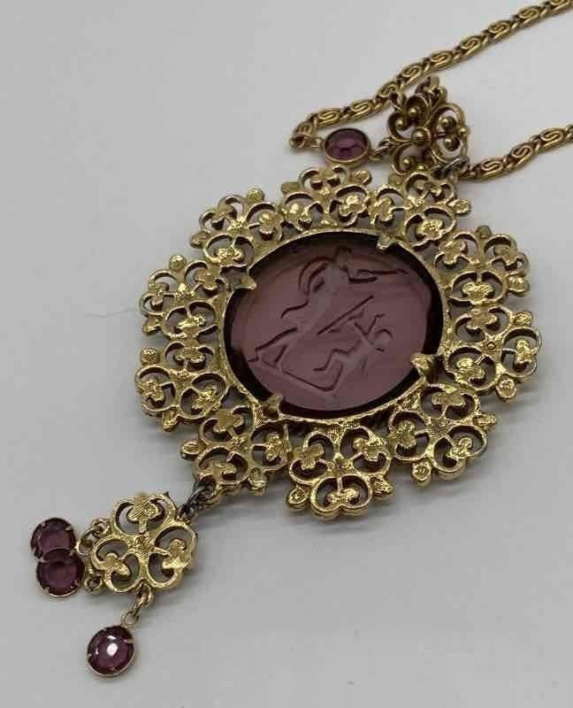 Purple glass pendant in gold necklace