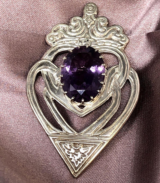 Purple amethyst and sterling silver brooch on pink cloth