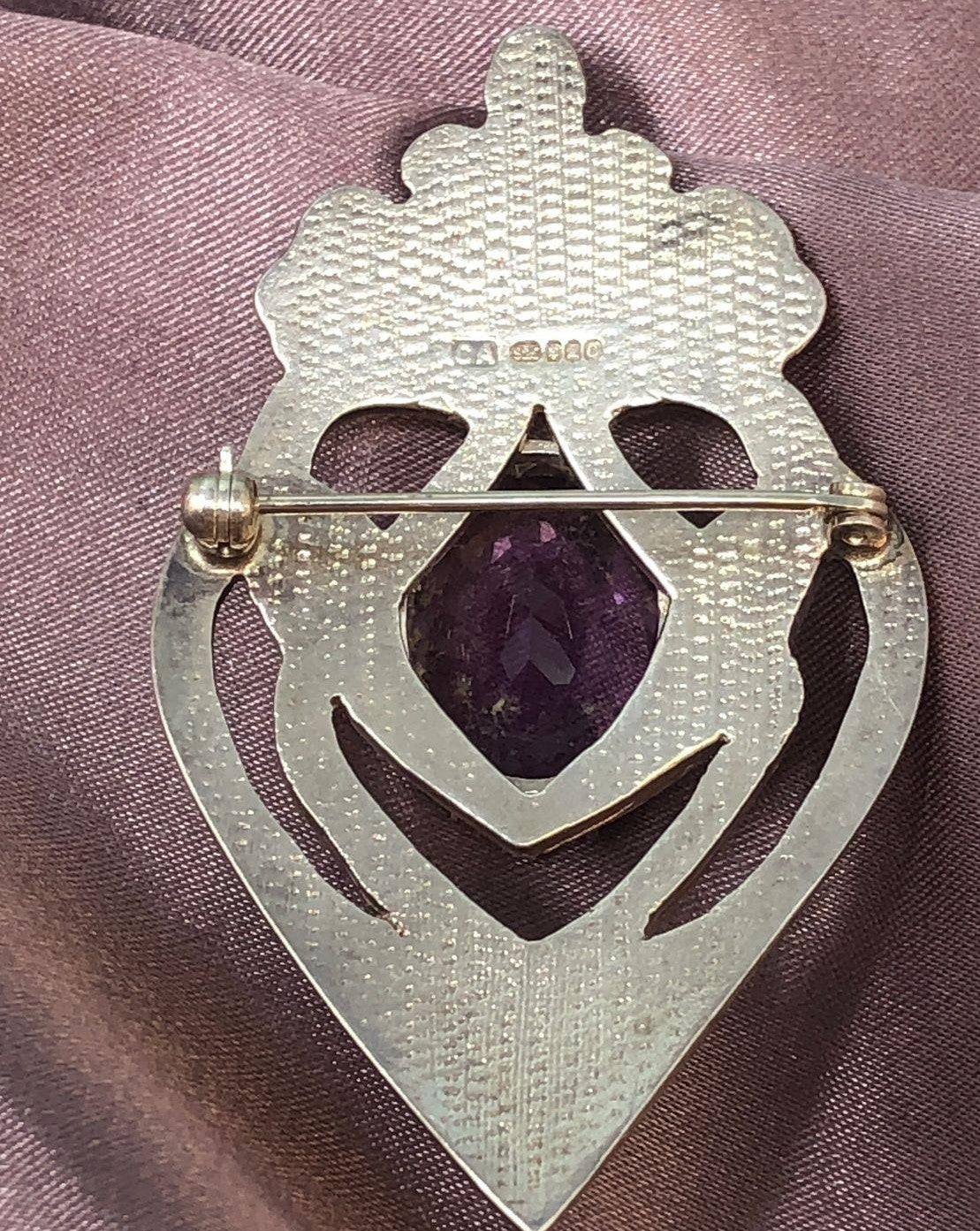 Back of silver brooch on pink cloth