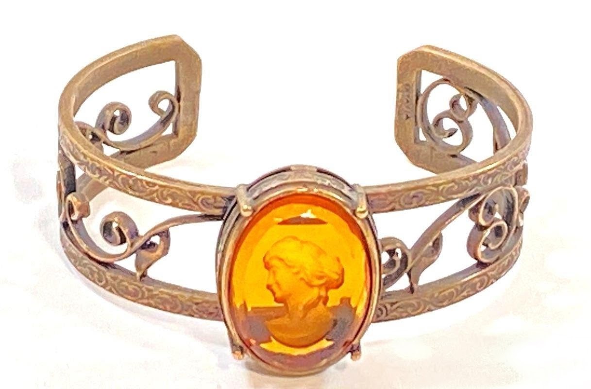 Bronze cuff bracelet with Abackgroundmber glass carving on white 