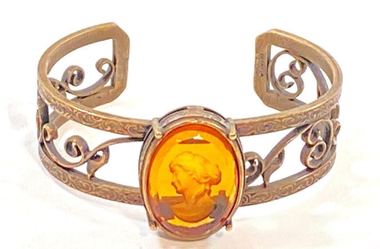 Bronze cuff bracelet with Abackgroundmber glass carving on white 