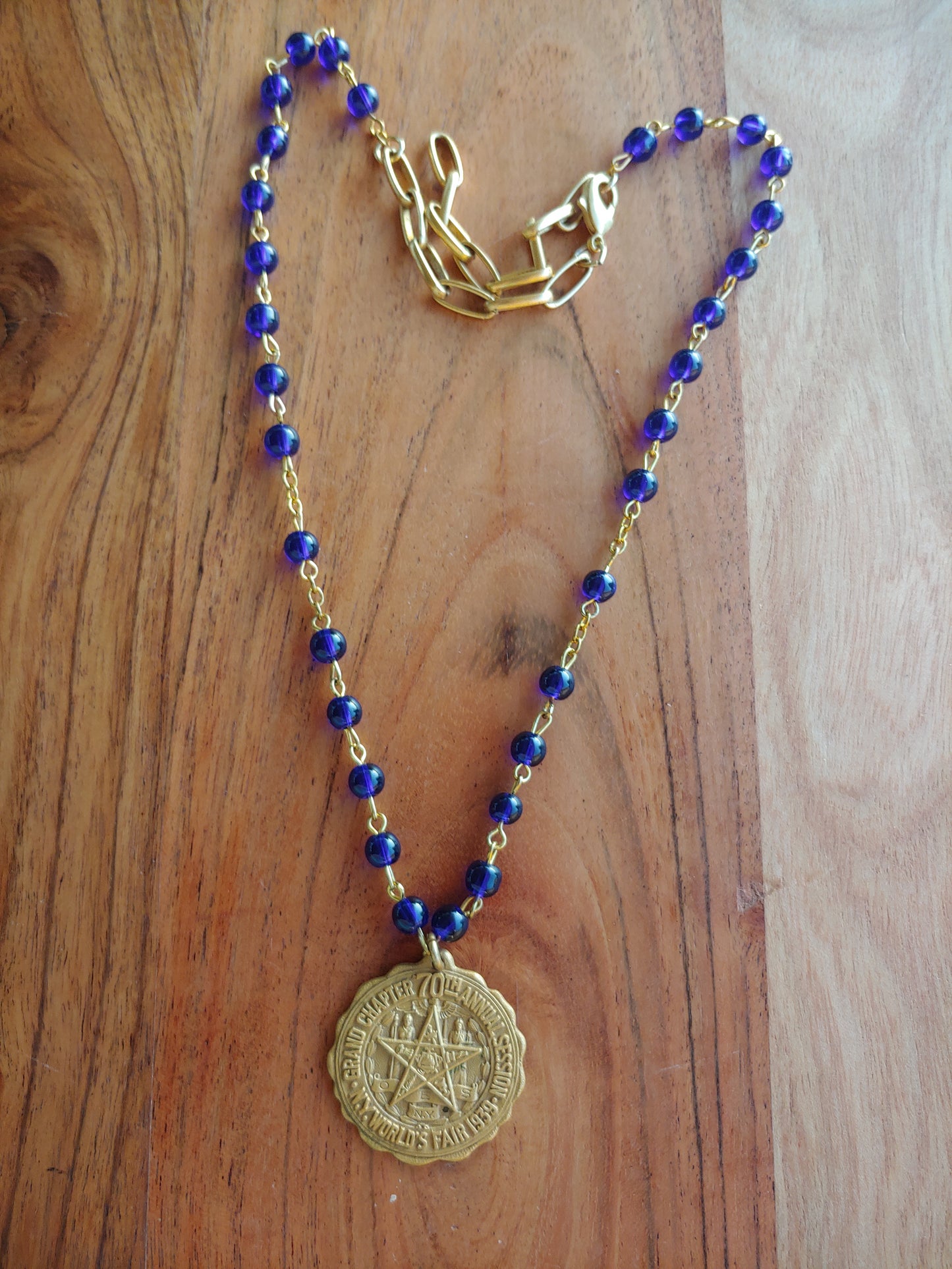 Brass charm on blue necklace